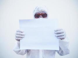 joven médico o científico con uniforme de suite ppe sosteniendo papel en blanco para texto con ambas manos mientras mira hacia adelante. concepto de coronavirus o covid-19 fondo blanco aislado foto