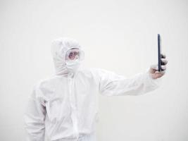 Young doctor or scientist in PPE suite uniform while using his phone for selfie and video chats with family or freind. coronavirus or COVID-19 concept isolated white background photo