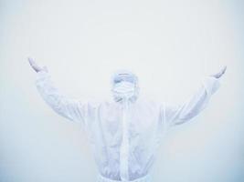 Positive young doctor or scientist in PPE suite uniform raising both hands to empty space above. coronavirus or COVID-19 concept isolated white background photo