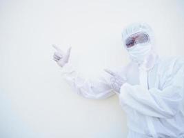 Asian male doctor or scientist in PPE suite uniform showing pointing two fingers away at copy space while standing and looking forward. coronavirus or COVID-19 concept isolated white background photo