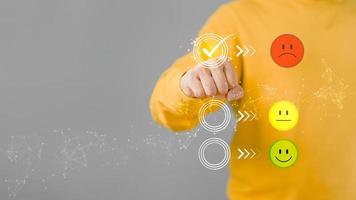 Man touching the virtual screen on the unhappy angry face icon in give rating to service experience on application. Online customer review satisfaction feedback survey. photo