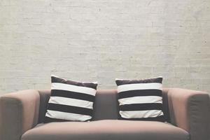 Black and white patterned pillow Modern sofa a background Brick wallpaper. photo