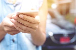 close up hand people woman stand using the mobile smart phone in the roadside wayside. call a car mechanic ask for help assistance because car broken. photo