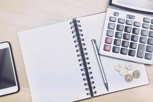 Money calculator and notebook,notepad,pen  on wood table, top view with copy space - financial background concept photo