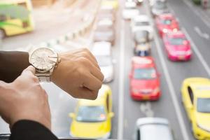 young businessman looks at the watch on the road in rush hour. photo