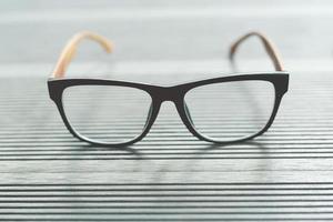 Close up eyeglasses fashion on the table wood color grey. photo