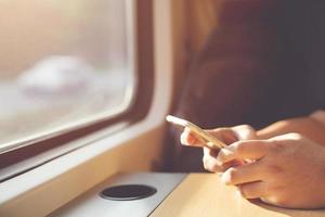 Young man traveler with backpack and Travel equipment sit use phone on public car. Travel concept. photo