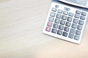 close up calculator focus at on press button keyboard on the wood table office. concept calculate account finance. photo