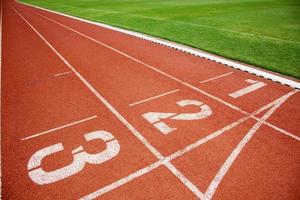 pista de atletismo o pista de atletismo con tres números de carriles y césped foto