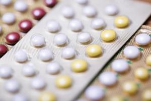 Close up Oral contraceptive pill on pharmacy counter with colorful pills strips. Contraception reduces childbirth concept. photo