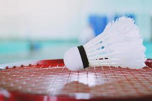 volante blanco y raqueta de bádminton roja en la cancha de bádminton. foto