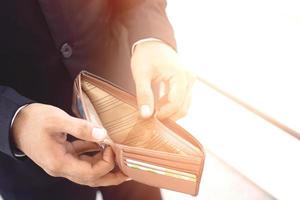 Empty wallet no money in the hands of an man. Cost control expenses poverty in concept. Leave space to write descriptive text. photo