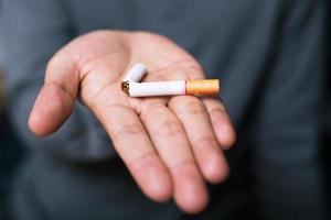 Man refusing cigarettes concept for quitting smoking and healthy lifestyle dark  background. or No smoking campaign Concept. photo