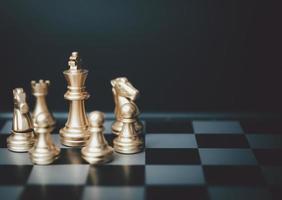 Close up of hands of a business man moving king golden chess to defeat  opponent the chess game is development analysis, strategy, and plan, the  management or leadership concept. 22804709 Stock Photo