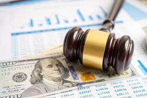 Gavel for judge lawyer with US dollar banknotes on chart graph paper, finance concept. photo