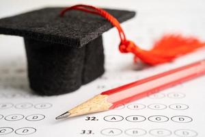 Graduation hat and pencil on Answer sheet background, Education study mathematics learning teach concept. photo