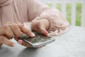 women pointing finger on broken smart phone screen photo