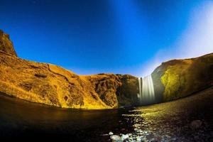 skogafoss, una cascada situada en el río skoga en el sur de islandia en los acantilados de la antigua costa foto