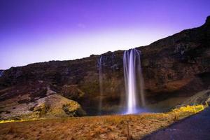 Seljalandsfoss, a waterfall with a small cave behind it in the south region in Iceland, it is part of the Seljalands River that has its origin in the volcano glacier Eyjafjallajokull photo