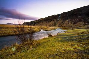 Seljalandsfoss, a waterfall with a small cave behind it in the south region in Iceland, it is part of the Seljalands River that has its origin in the volcano glacier Eyjafjallajokull photo