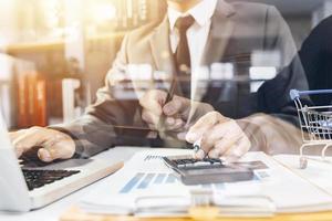 Business partnership coworkers using a tablet to analysis graph company financial budget report and cost work progress and planning for future in office room. photo