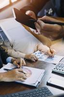 compañeros de trabajo de la sociedad comercial que usan una tableta para analizar el informe del presupuesto financiero de la empresa y el progreso del trabajo de costos y la planificación para el futuro en la sala de la oficina. foto