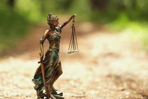 estatua de themis contra un fondo de naturaleza. símbolo de justicia y ley, crimen y castigo. foto