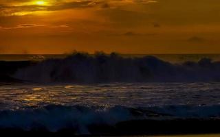 Colorful golden sunset big wave and beach Puerto Escondido Mexico. photo