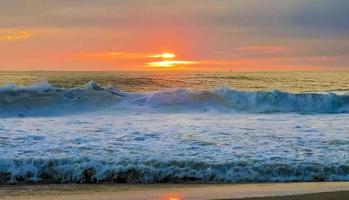 colorido atardecer dorado gran ola y playa puerto escondido mexico. foto