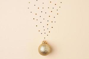 Christmas pastel beige minimal background with beige ball and confetti. Flat lay, copy space photo