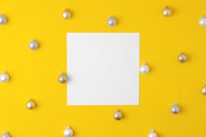 Christmas yellow minimal background with mock up greetings card and ball. Flat lay, copy space photo