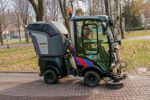 dnepropetrovsk, ucrania - 22.11.2021 el servicio municipal realiza trabajos estacionales en el parque. los cepillos barren el asfalto. foto