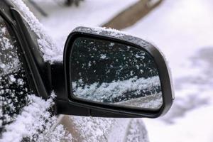 Car mirror in the snow. Winter concept. Part of the car photo