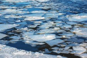 Winter nature background with blocks of ice on frozen water in spring. Abstract background of drifting ice on water photo