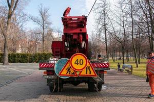 Dnepropetrovsk, Ukraine - 11.22.2021 A mobile crane with an orange color basket is used in a public park to trim trees. photo