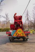 Dnepropetrovsk, Ukraine - 11.22.2021 A mobile crane with an orange color basket is used in a public park to trim trees. photo