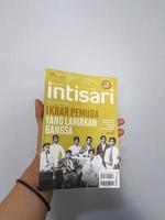 West Java, August 2022. A hand is holding an Intisari magazines. October 2021 edition with the theme Pledge of Youth Born by the Nation. photo