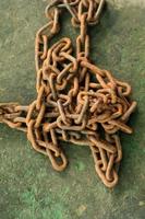 Rusty and dirty steel chains on cement floor in front of the house for locking valuable assets such as motorcycles and bicycles to prevent guerrilla theft. photo