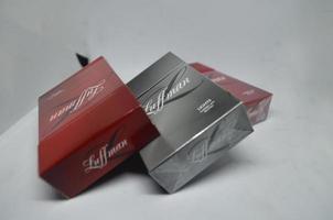 BLITAR, INDONESIA - September 30th 2022 Flat view Three packs of Luffman brand cigarettes in two color variants, red and black isolated on a white background photo