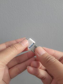 A hand is trying to insert a small flask disk into a Adapter USB Type C to USB 3.0 Type-C adapter OTG photo