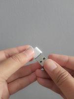 una mano está tratando de insertar un disco de matraz pequeño en un adaptador usb tipo c a adaptador usb 3.0 tipo c otg foto