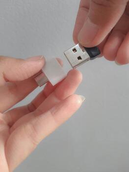 A hand is trying to insert a small flask disk into a Adapter USB Type C to USB 3.0 Type-C adapter OTG photo