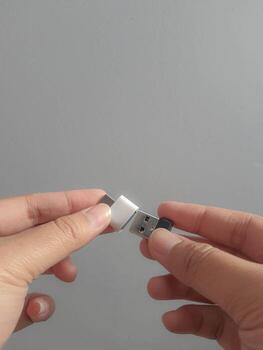 A hand is trying to insert a small flask disk into a Adapter USB Type C to USB 3.0 Type-C adapter OTG photo