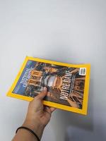 West Java in August 2022. A hand holds the Indonesian version of the National Geographic magazine. photo