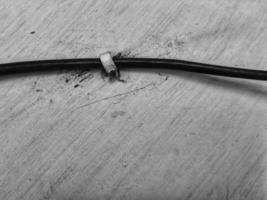 A black cable trimmed with cable nail clips photo