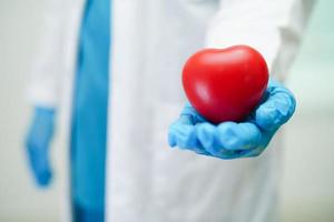 Asian woman doctor holding red heart for health in hospital. photo