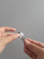 A hand is trying to insert a small flask disk into a Adapter USB Type C to USB 3.0 Type-C adapter OTG photo