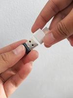 A hand is trying to insert a small flask disk into a Adapter USB Type C to USB 3.0 Type-C adapter OTG photo