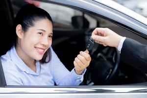 The saleswoman holds the new car keys. Ready to deliver to customers at the showroom. photo