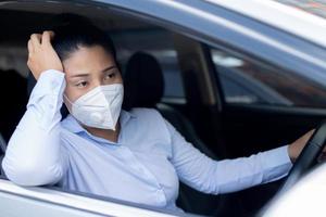 Woman is wearing masks before driving every time to prevent the corona virus. photo